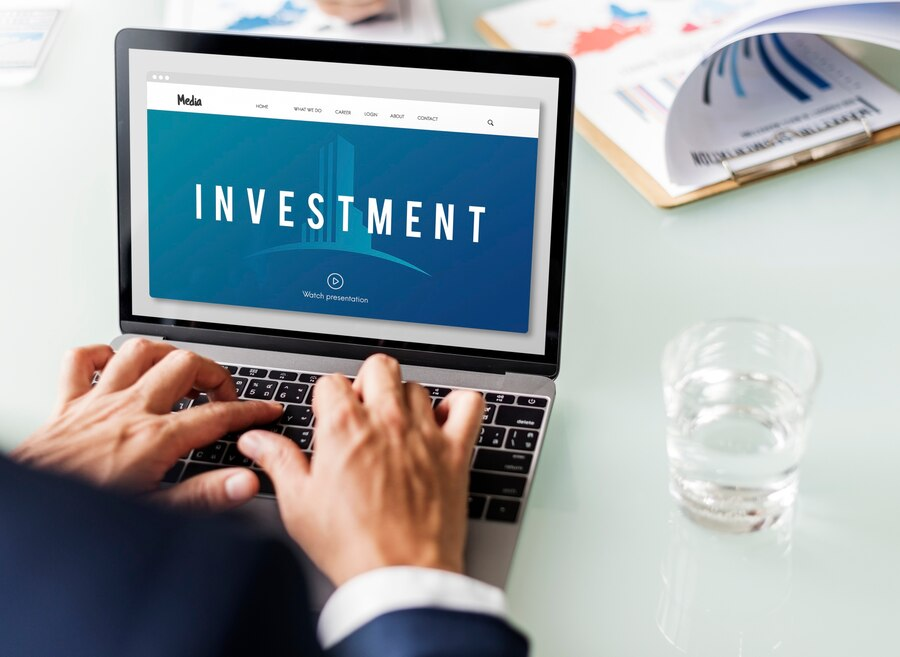 Man using a laptop “investment” displayed on screen 